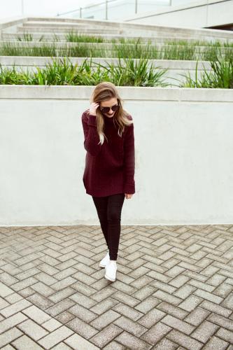 Young woman walking in city wearing sunglasses - Australian Stock Image