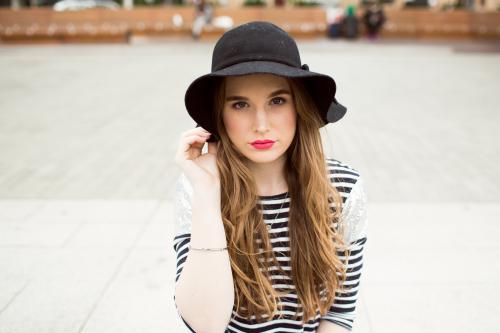 Young woman wearing a hat looking at camera