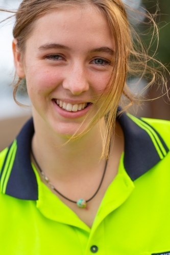 Young woman with messy hair wearing hi vis smiling - Australian Stock Image