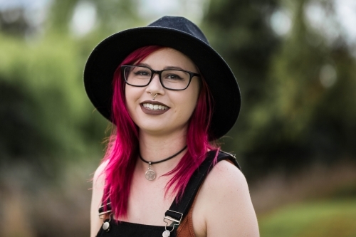 Young woman with nose piercing and red hair smiling