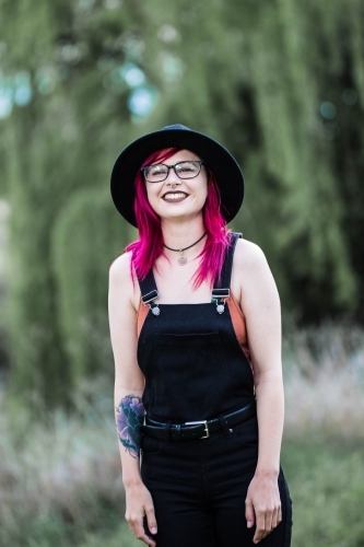 Young woman with pink hair standing laughing - Australian Stock Image