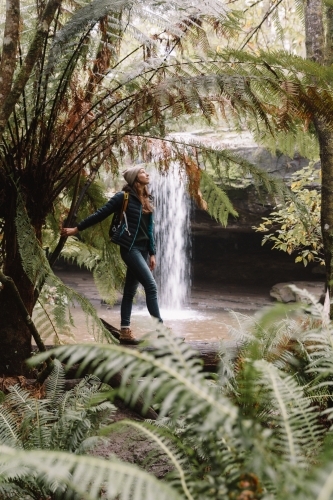 Young women bushwalking in temperate rainforest amongst ferns