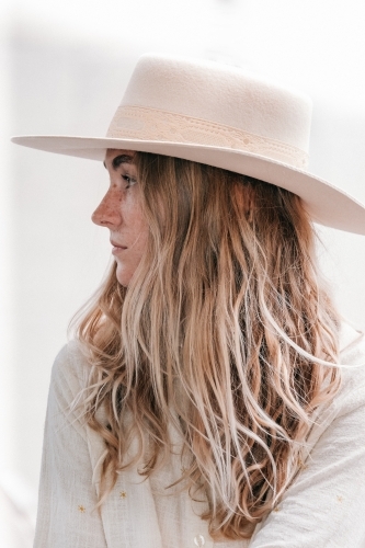 Young womens profile wearing a hat.